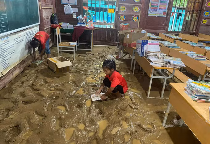 Học sinh thu dọn sách vở ngấm bùn