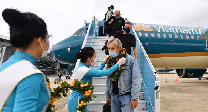 Đoàn khách đầu tiên được tặng hoa ngay khi xuống tàu bay