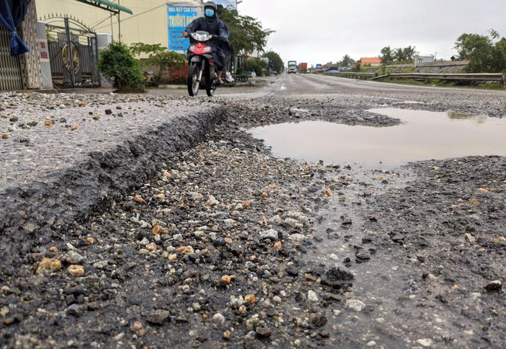 Mặt đường Quốc lộ 1 ở thị xã Đức Phổ bong tróc, nhiều ổ gà đọng nước