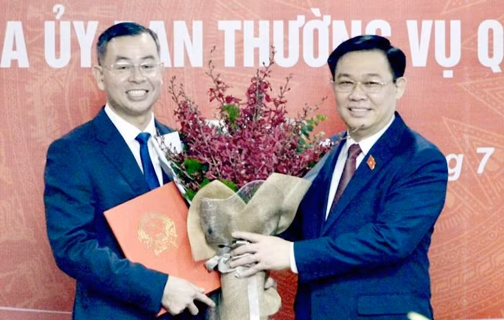 Ông Ngô Văn Tuấn (trái) nhận hoa chúc mừng từ Chủ tịch Quốc hội Vương Đình Huệ