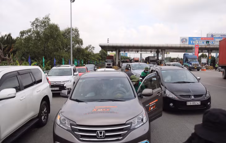 Nhiều xe dừng để dán thẻ thu phí tự động ETC, cách trạm thu phí khoảng 30 m.