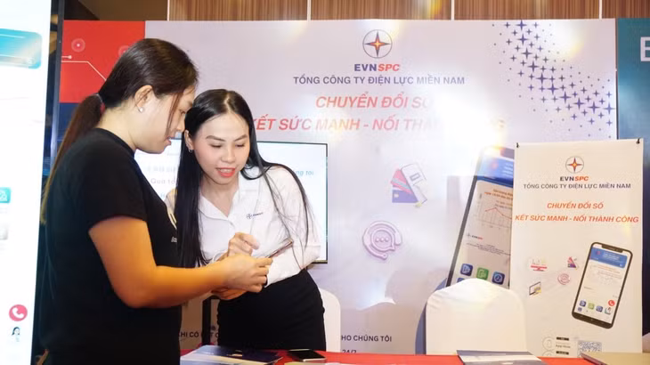 Nhân viên TTCSKH hướng dẫn khách tham quan trải nghiệm App CSKH EVNSPC - Ảnh: Đức Tuân