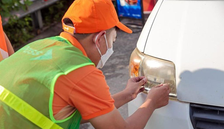 Nhân viên của Công ty cổ phần Giao thông số Việt Nam (VDTC) dán thẻ thu phí không dừng cho phương tiện.