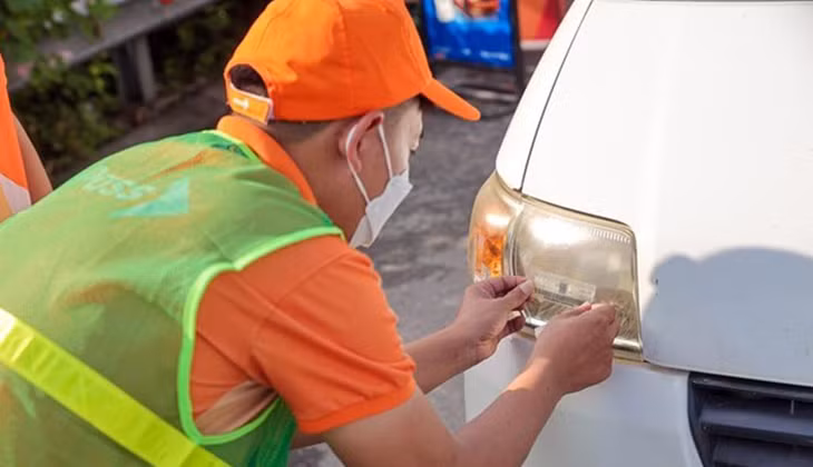 Nhân viên của Công ty cổ phần Giao thông số Việt Nam (VDTC) dán thẻ thu phí không dừng cho phương tiện.