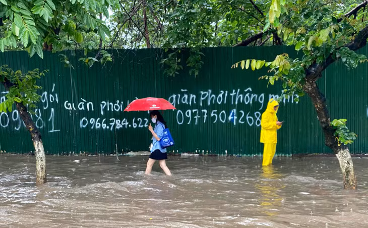 Người đi bộ không còn cách nào khác phải đánh liều đi dò chân từng bước trên vỉa hè. Công nhân thoát nước cũng đã có mặt, đứng chặn và cảnh báo người dân tránh đi qua các điểm có hố sâu hoặc cống thoát nước đang mở nắp