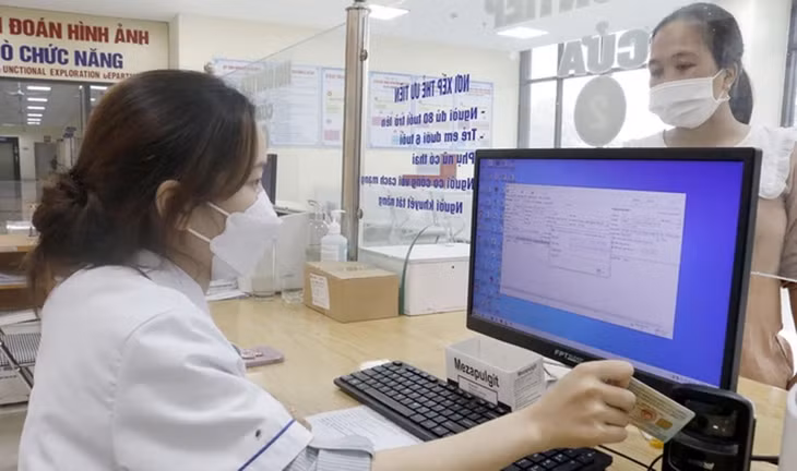 Nhân viên y tế dùng máy quét QR code trên căn cước công dân gắn chíp để tra cứu thông tin người bệnh