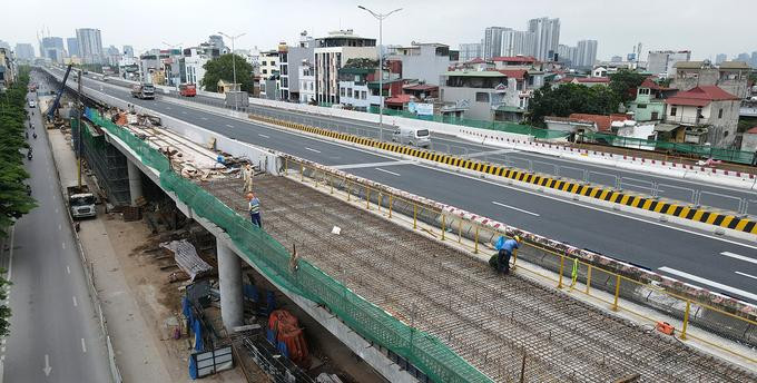 Tại nhánh lên xuống nút giao Cổ Nhuế, hàng chục công nhân đang thi công bản mặt cầu để chuẩn bị đổ bê tông vào ngày 23/4