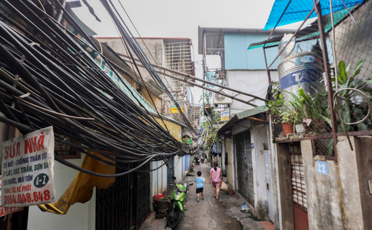 Những bó dây điện, cáp viễn thông chằng chịt, chắn cửa nhiều ngôi nhà trong con ngõ rộng hơn 2 m trên đường Đê La Thành, quận Ba Đình