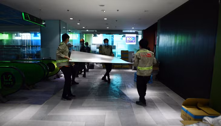 Phía dưới khu căn hộ, công nhân đang gấp rút cải tạo khu trung tâm thương mại thành bệnh viện dã chiến.