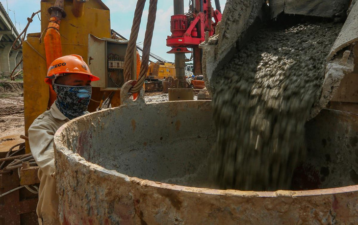 Các công nhân đổ bê tông xuống các hố khoan. Để đảm bảo an toàn công trường trong mùa dịch Covid-19, quá trình đi lại, ăn ở của họ hạn chế việc tiếp xúc với người ngoài.