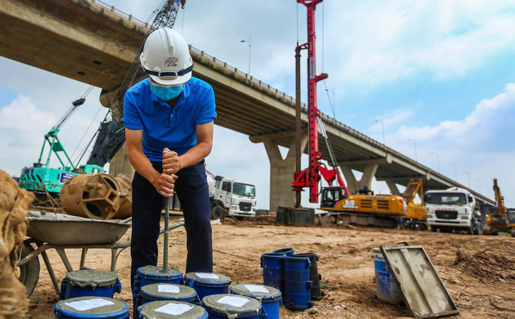 Một kỹ sư đang lấy mẫu kiểm tra đối chứng bê tông. “Mỗi mẻ bê tông đều được chúng tôi lấy mẫu. Mẫu sẽ được nén sau đó kiểm tra cường bộ. Bê tông được sử dụng thi công phải đảm bảo theo tiêu chuẩn thiết kế”, đại diện Ban Quản lý dự án đầu tư xây dựng công trình giao thông Hà Nội nói.