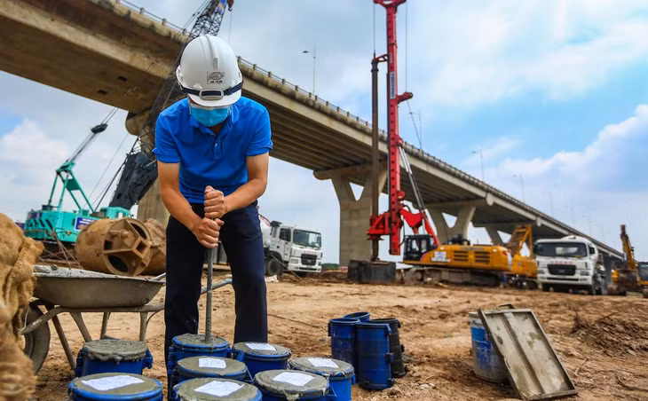 Một kỹ sư đang lấy mẫu kiểm tra đối chứng bê tông. “Mỗi mẻ bê tông đều được chúng tôi lấy mẫu. Mẫu sẽ được nén sau đó kiểm tra cường bộ. Bê tông được sử dụng thi công phải đảm bảo theo tiêu chuẩn thiết kế”, đại diện Ban Quản lý dự án đầu tư xây dựng công trình giao thông Hà Nội nói.