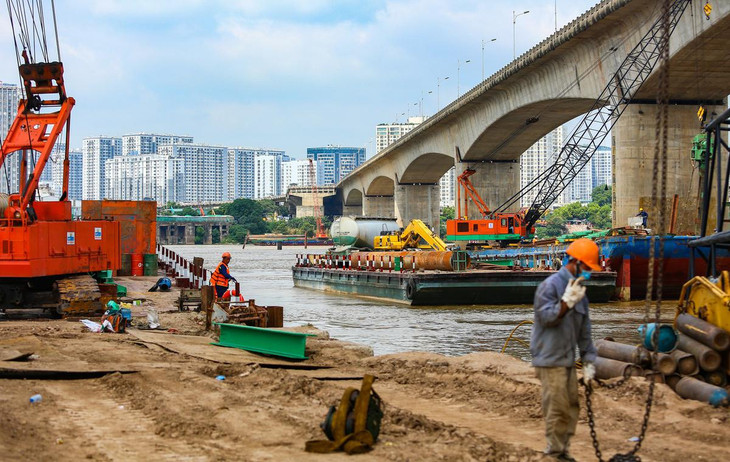 Theo đại diện liên danh nhà thầu, công nhân đang khoan cọc nhồi và khảo sát lòng sông. Do triển khai vào mùa mưa lũ, đơn vị thi công phải thuê một cơ quan phụ trách phân luồng tàu bè, đảm bảo an toàn giao thông đường thủy qua khu vực.