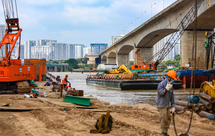 Theo đại diện liên danh nhà thầu, công nhân đang khoan cọc nhồi và khảo sát lòng sông. Do triển khai vào mùa mưa lũ, đơn vị thi công phải thuê một cơ quan phụ trách phân luồng tàu bè, đảm bảo an toàn giao thông đường thủy qua khu vực.
