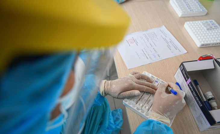 Nhân viên y tế sau khi tiếp nhận thông tin hành khách sẽ điền các mã số riêng cho từng hành khách trên các kit lấy mẫu xét nghiệm.