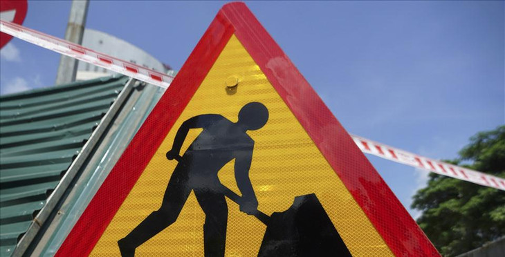 Ngoài việc cố định chân rào chắn xuống lòng đường, đơn vị thi công cũng tiến hành giăng dây, dựng biển cảnh báo cho các phương tiện giao thông.