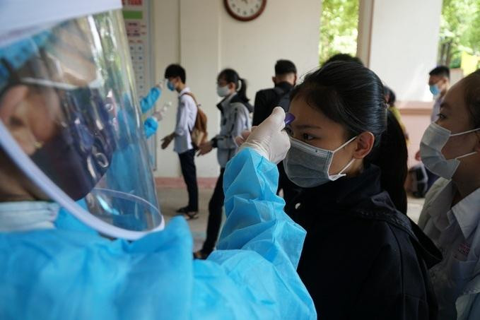 Học sinh trường THPT Trần Quốc Tuấn, TP Quảng Ngãi, đo thân nhiệt trước khi làm thủ tục dự thi tốt nghiệp THPT hồi tháng 8