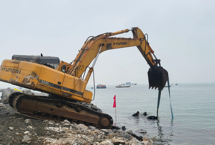 Thợ lặn đang cố định các giỏ đá dưới nước để phần cầu tạm phục vụ sà lan neo đậu tiếp nhận và vận chuyển khối phủ sóng Rakuna phục vụ thi công phần thân đê.