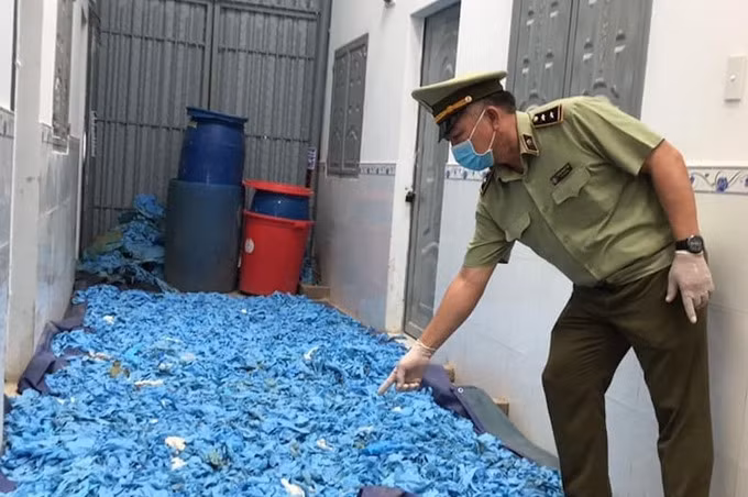 Găng tay cao su qua sử dụng được rải dưới nền nhà, chuẩn bị sơ chế lại thì bị lực lượng quản lý thị trường phát hiện, thu giữ