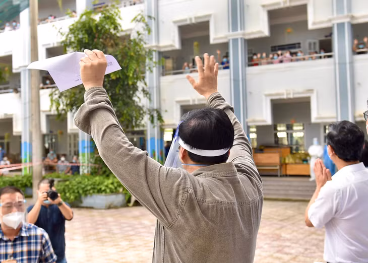 Thủ tướng vẫy chào bà con đang thực hiện cách ly tập trung tại Trường Tiểu học Bình Thuận, phường Thuận Giao, TP. Thuận An. Ảnh: VGP