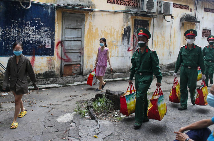 Các chiến sĩ thuộc Sư đoàn 302 (Quân khu 7) trao thực phẩm cứu trợ cho người dân ở một con hẻm thuộc Phường 4, Quận 5