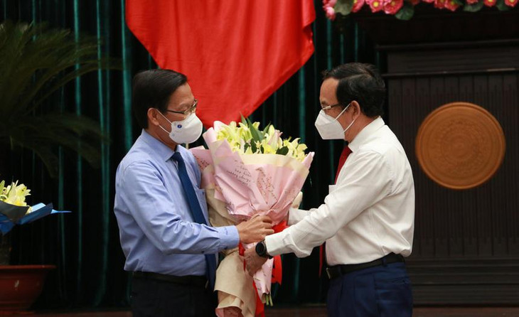 Tân Chủ tịch UBND TP.HCM Phan Văn Mãi nhận hoa chúc mừng từ Bí thư Thành ủy TP.HCM Nguyễn Văn Nên