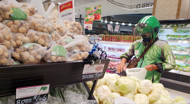 Khi người dân đặt hàng trên ứng dụng, cán bộ đi chợ hộ sẽ nhận được thông báo qua ứng dụng Grab và đến đơn vị cung ứng hàng hóa để nhận hàng,