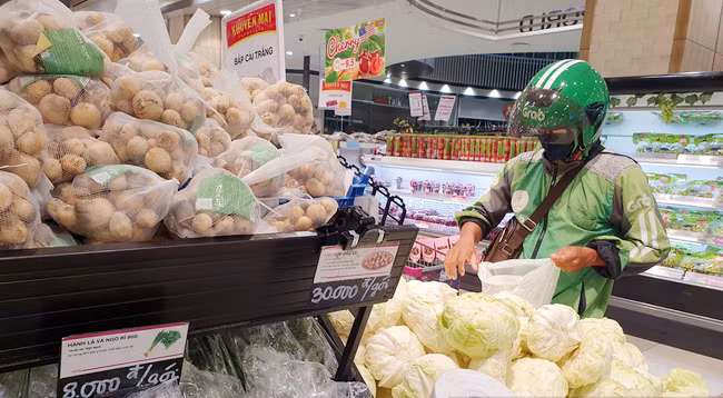 Khi người dân đặt hàng trên ứng dụng, cán bộ đi chợ hộ sẽ nhận được thông báo qua ứng dụng Grab và đến đơn vị cung ứng hàng hóa để nhận hàng,