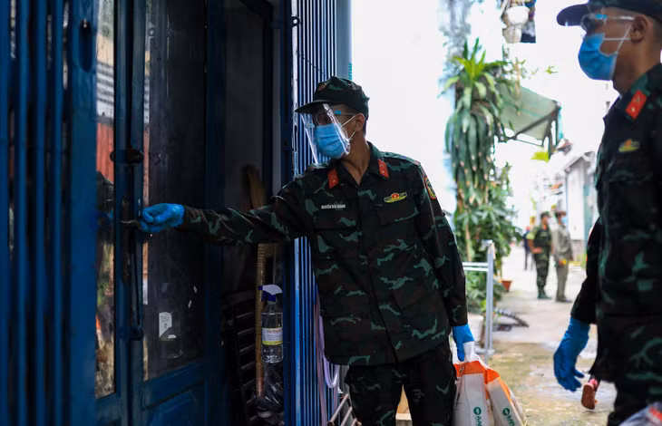 Với các căn nhà khóa cửa, bộ đội gõ cửa và gọi gia chủ ra nhận quà.