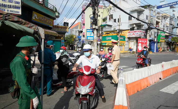 Cán bộ gác chốt kiểm tra giấy đi đường của một nhân viên viễn thông thuộc trường hợp có giấy đi đường đánh dấu 1A