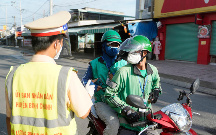 Lực lượng gác chốt trước khu công nghiệp Vĩnh Lộc yêu cầu hai shipper quay lại với lý do đi tiêm vắc xin nhưng không có giấy hẹn