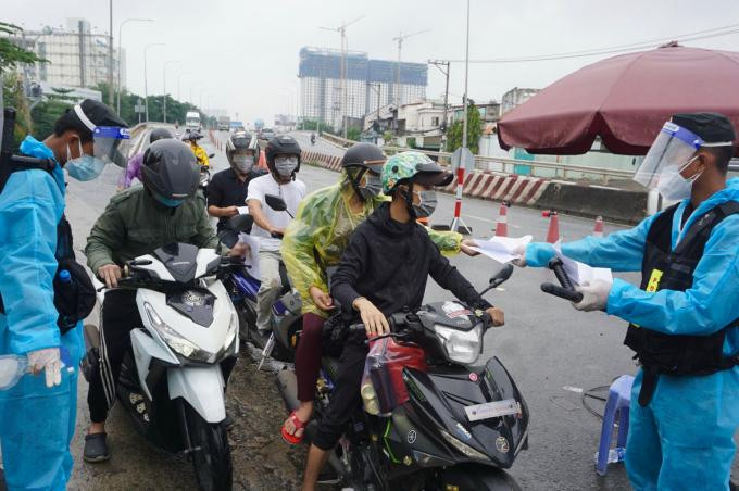 Người dân xuất trình giấy tờ để kiểm tra tại chốt kiểm soát cầu Vĩnh Bình, giáp TP. Thủ Đức và tỉnh Bình Dương