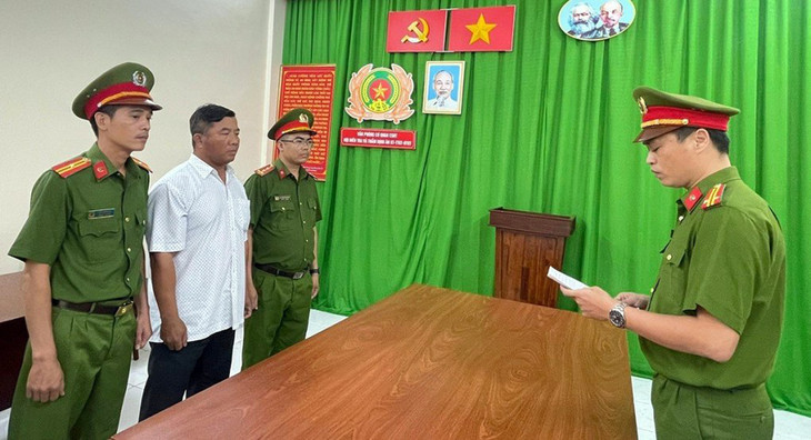 Ông Phạm Hoài Hà (áo trắng) nghe cảnh sát đọc quyết định tạm giam