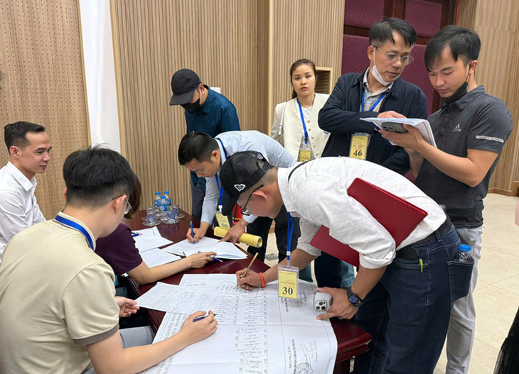 Khách hàng trúng đấu giá ký nhận sơ đồ thửa đất. Ảnh: UBND huyện Ứng Hòa