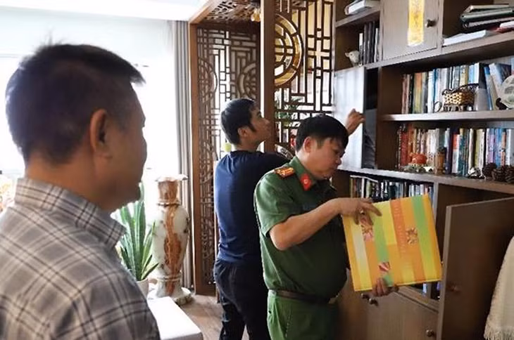 Ông Trần Huy Lập (trái) chứng kiến cơ quan điều tra khám xét