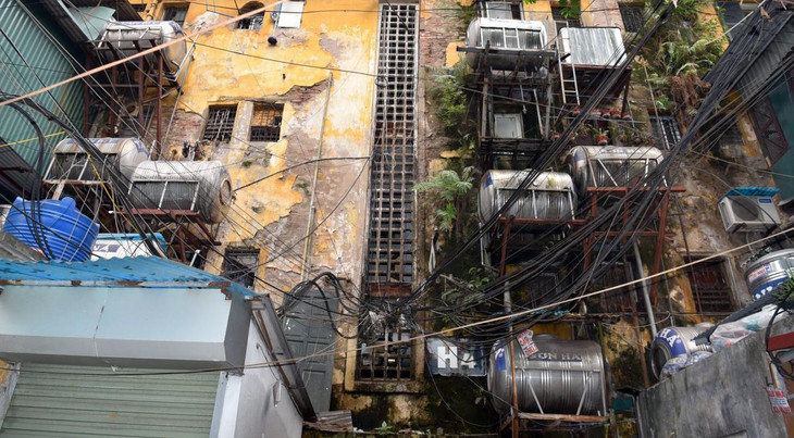 Những dãy nhà cũ kỹ cõng trên lưng những bể nước treo được người dân hàn khung bắt vào tường