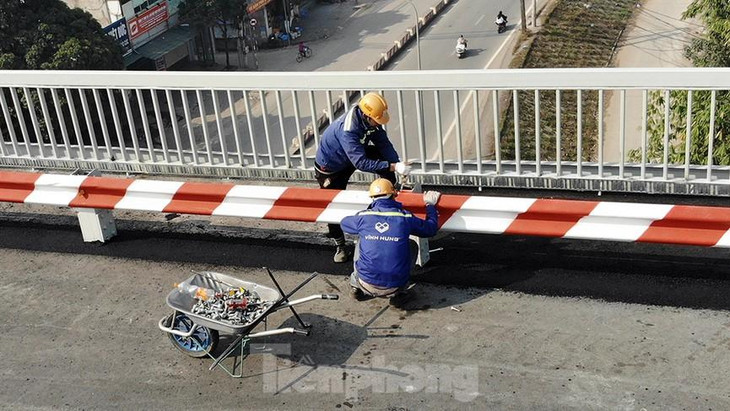 Công nhân đang lắp đặt lại hệ thống ta luy 2 bên thành cầu.