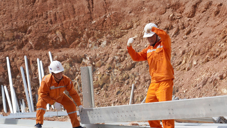 Anh Phan Văn Điền (bên phải) đang cùng anh em công nhân phân loại thanh thanh sắt để tiến hành dựng trụ (Đội xung kích EVNHCMC)