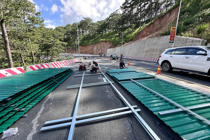 Công nhân thi công rào chắn tại vị trí mặt đường đèo bị rạn nứt