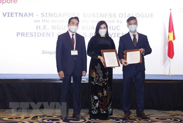 Doanh nghiệp hai nước trao đổi các hợp đồng, thỏa thuận hợp tác tại cuộc Đối thoại doanh nghiệp Việt Nam-Singapore. Ảnh: TTXVN