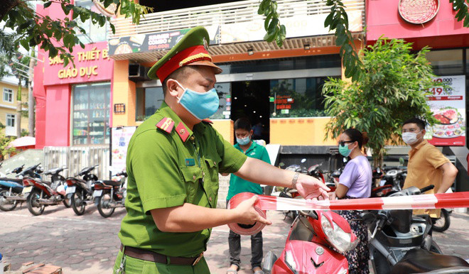 Cảnh sát chăng dây phong tỏa quán pizza có ca nghi nhiễm.