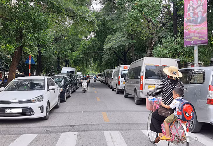 Xe đỗ kín hai bên lề đường tại phố Đinh Núp, quận Cầu Giấy, Hà Nội, khiến diện tích lòng đường bị thu hẹp