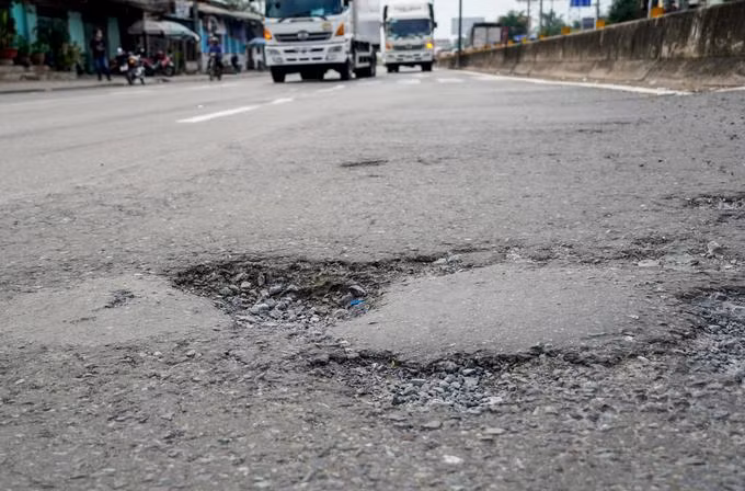 Mặt đường Quốc lộ 1, đoạn qua huyện Châu Thành, Tiền Giang bị bong tróc