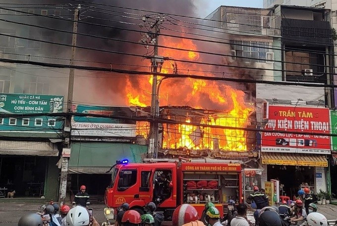 Cảnh sát dập lửa tại một đám cháy trên Quốc lộ 13, quận Bình Thạnh