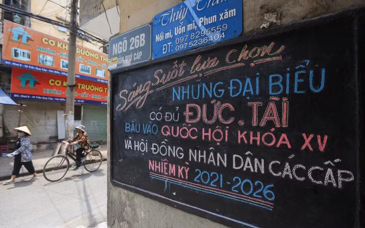 Khẩu hiệu “Sáng suốt lựa chọn những đại biểu có đủ đức, tài bầu vào Quốc hội khoá XV và HĐND các cấp nhiệm kỳ 2021 - 2026” viết bằng phấn màu trên bảng đen đặt ngay đầu ngõ phố Trần Quý Cáp.