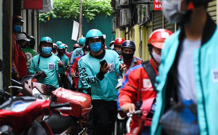 Một tiệm cơm tấm được đánh giá cao trên các ứng dụng đặt đồ ăn, lúc đầu chỉ khoảng từ 4-5 tài xế xếp hàng phía ngoài. Nhưng khi công an phường tới kiểm tra, hàng chục người từ trong quán ùa ra như vỡ trận.