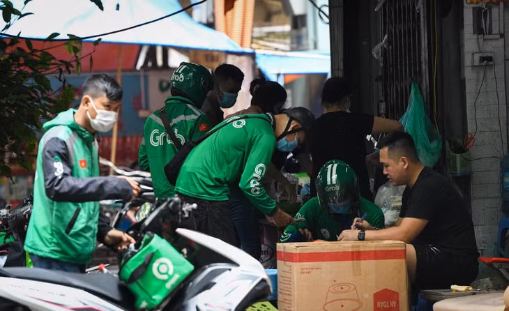 Tại một quán ăn trên đường Vũ Thạnh (Đống Đa, Hà Nội), các shipper chen chúc nhau để lấy đơn, tuy nhiên họ không đảm bảo an toàn về giãn cách phòng dịch. Còn chủ quán cũng không đeo khẩu trang khi làm việc. Tại một quán ăn trên đường Vũ Thạnh (Đống Đa, Hà Nội), các shipper chen chúc nhau để lấy đơn, tuy nhiên họ không đảm bảo an toàn về giãn cách phòng dịch. Còn chủ quán cũng không đeo khẩu trang khi làm việc.