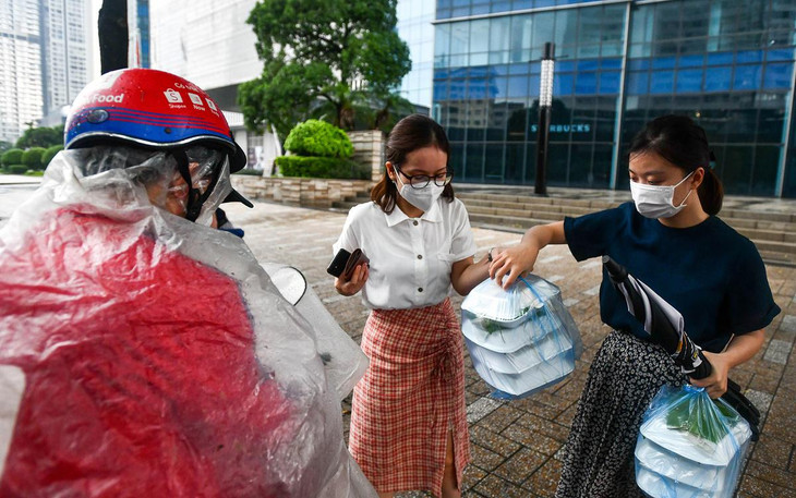 Sau khi trở lại làm việc tại công ty, chị Thủy (áo trắng) cùng đồng nghiệp đặt đồ ăn trưa qua ứng dụng trực tuyến. “Chỉ khi làm việc tại nhà tôi mới nấu nướng, còn khi ở công ty đặt sẽ tiện hơn”, chị nói.