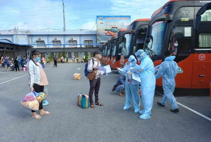 Người dân đưa giấy tờ kiểm tra trước khi lên xe tại Bến xe Miền Tây Người dân đưa giấy tờ kiểm tra trước khi lên xe tại Bến xe Miền Tây