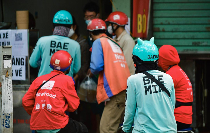 Tại nhiều tiệm bán đồ ăn, shipper chen chúc nhau không đảm bảo giãn cách. Một người giao hàng cho biết theo thông báo mới của công ty, chỉ có 50% tài xế của hãng được hoạt động.